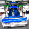 Front view of Aloha Splash inflatable water slide displaying vibrant blue and white design, single lane, palm tree decorations, and spacious splash pool in indoor setting.