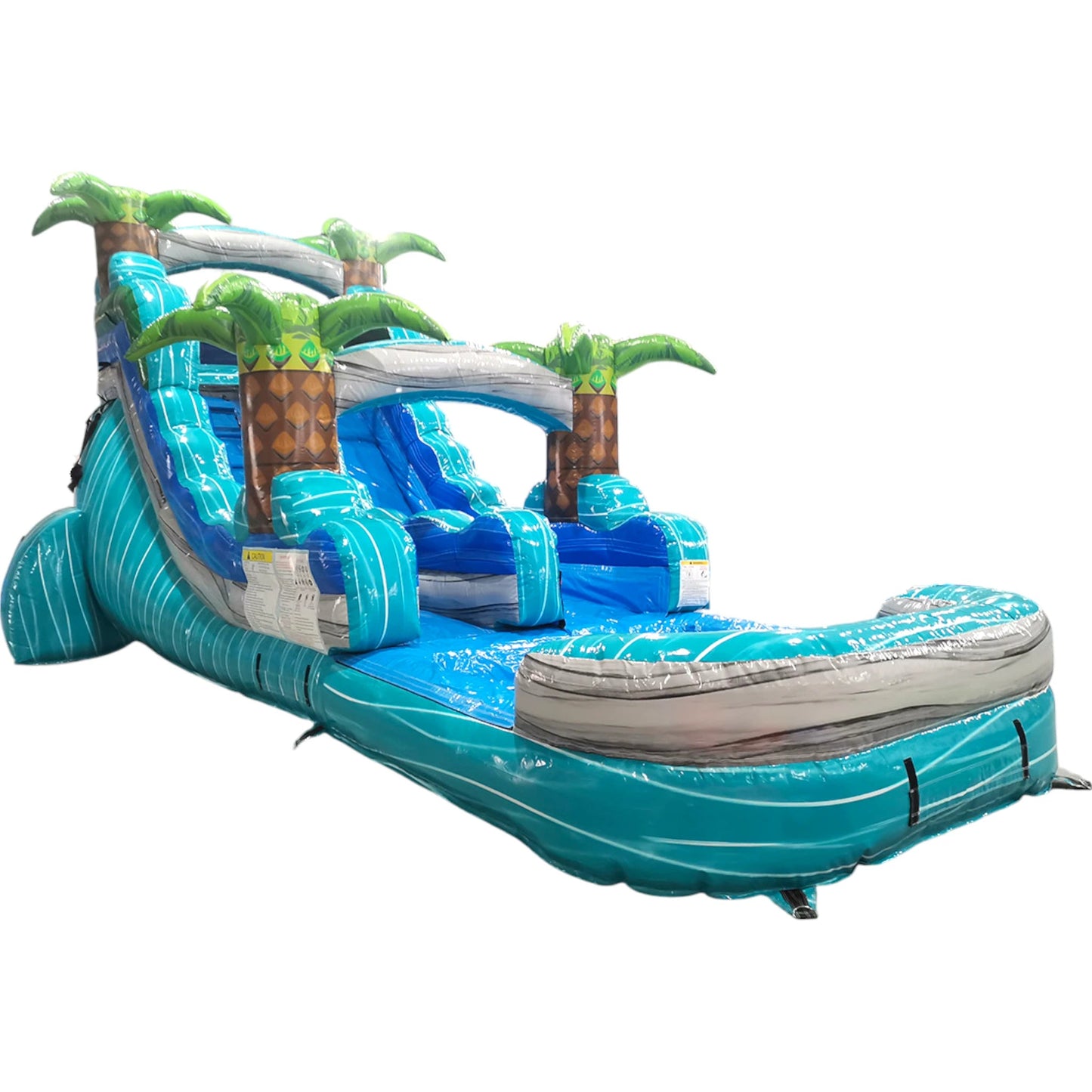 Large tropical-themed inflatable water slide featuring a single blue sliding lane, palm tree decorations, and an extended splash pool with turquoise and blue color scheme.