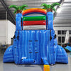 Rear view of Baja Splash single lane water slide, showcasing tall blue structure with climbing area, safety features, and tropical-themed top section with palm trees and rainbow arch.