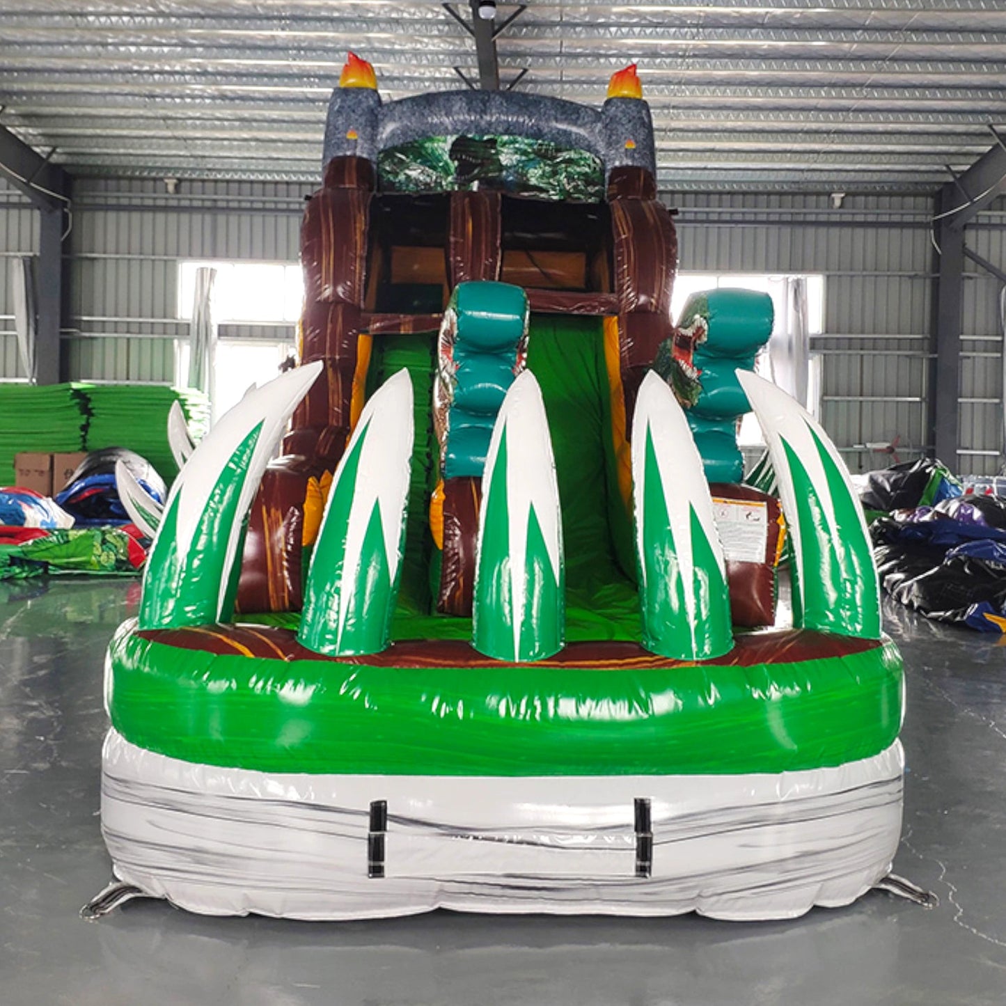 Front view of Dino Dive single lane water slide showing tall structure with dinosaur-themed decorations, green base, and brown sliding surface.