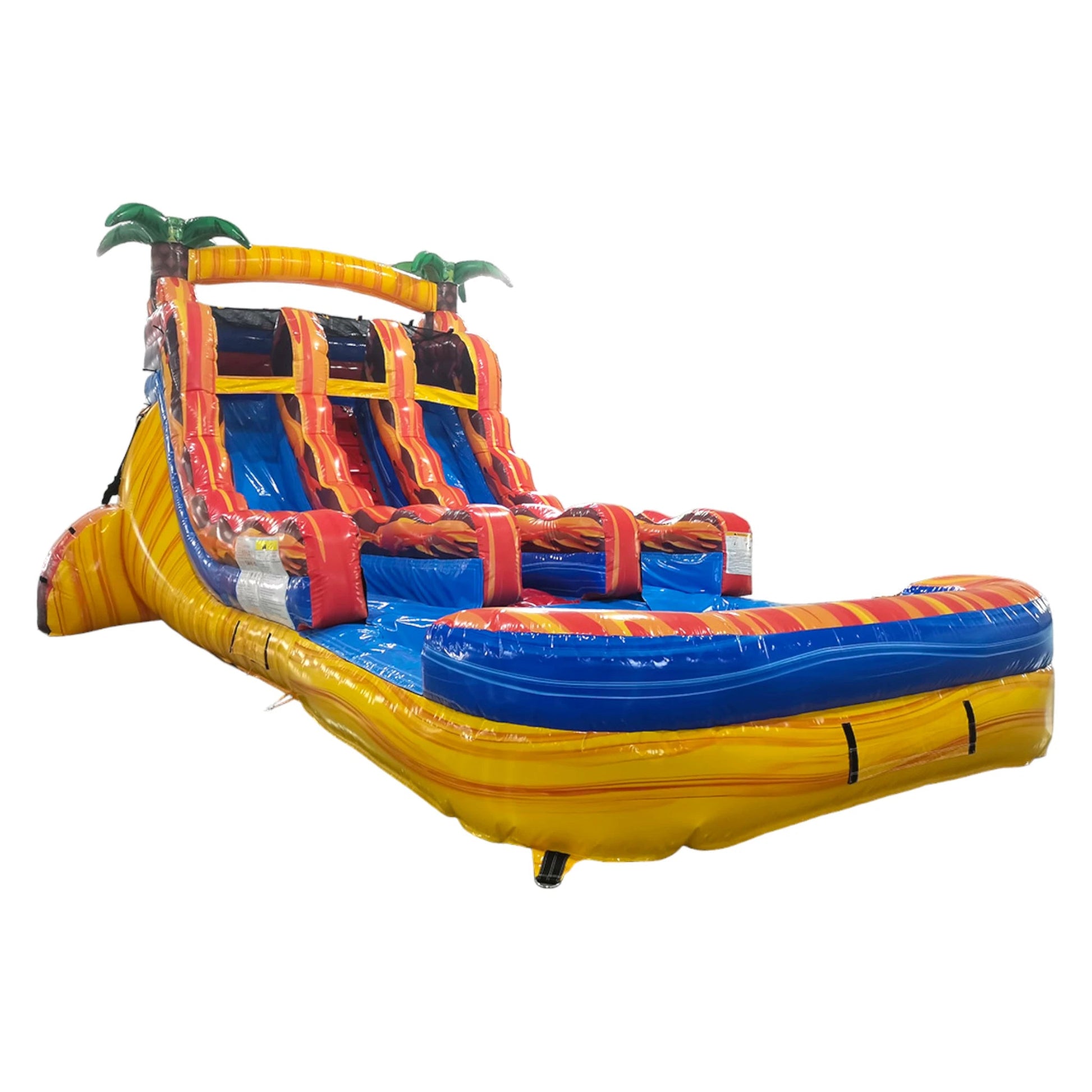 Colorful inflatable water slide with three lanes featuring red, orange, and yellow flame designs, palm tree decorations, and a central climbing structure, set up in an indoor warehouse.