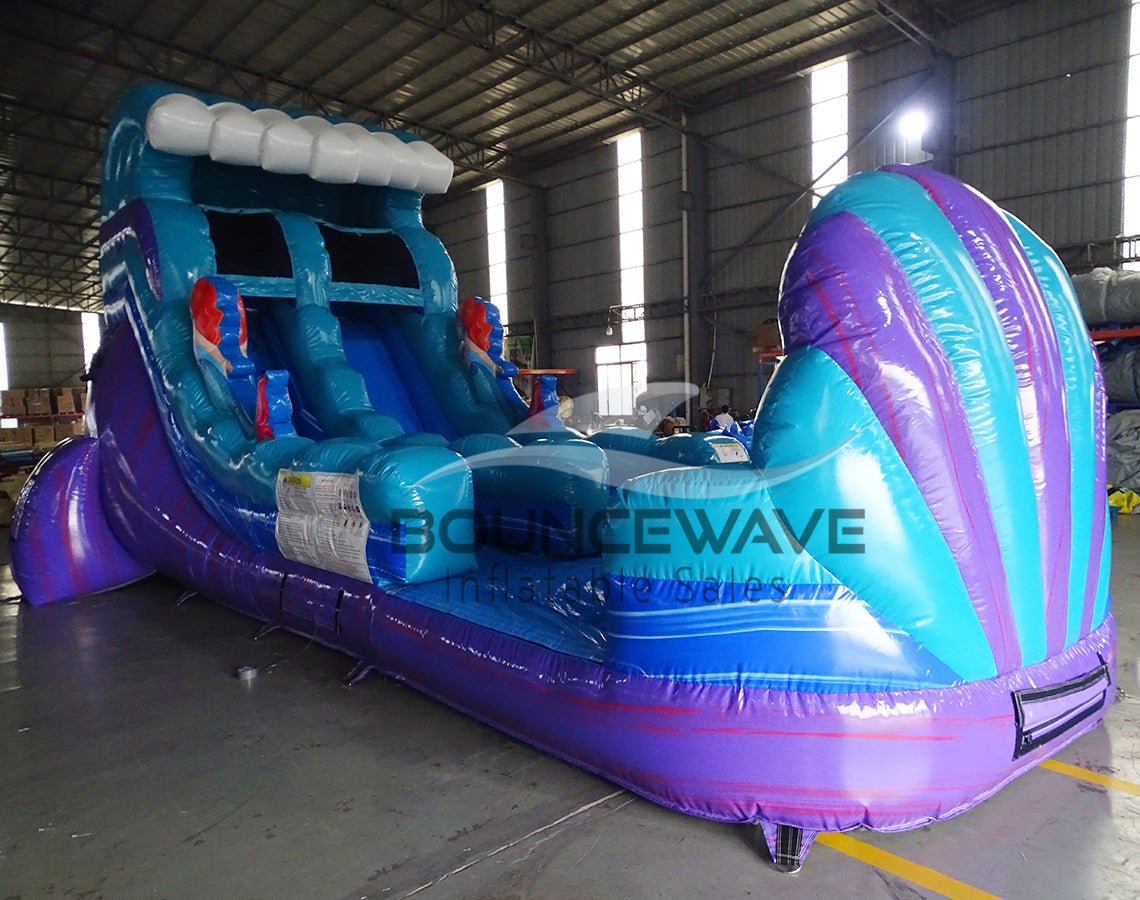 15ft Mermaid Commercial Single Lane Inflatable Water Slide side view showcasing blue structure, purple accents, wave-shaped slide, and extended splash pool in indoor facility
