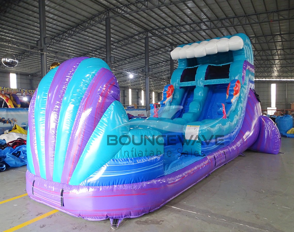 15ft Mermaid Commercial Single Lane Inflatable Water Slide front view displaying tropical-themed banner, blue curved slide, and purple inflatable base with BounceWave branding
