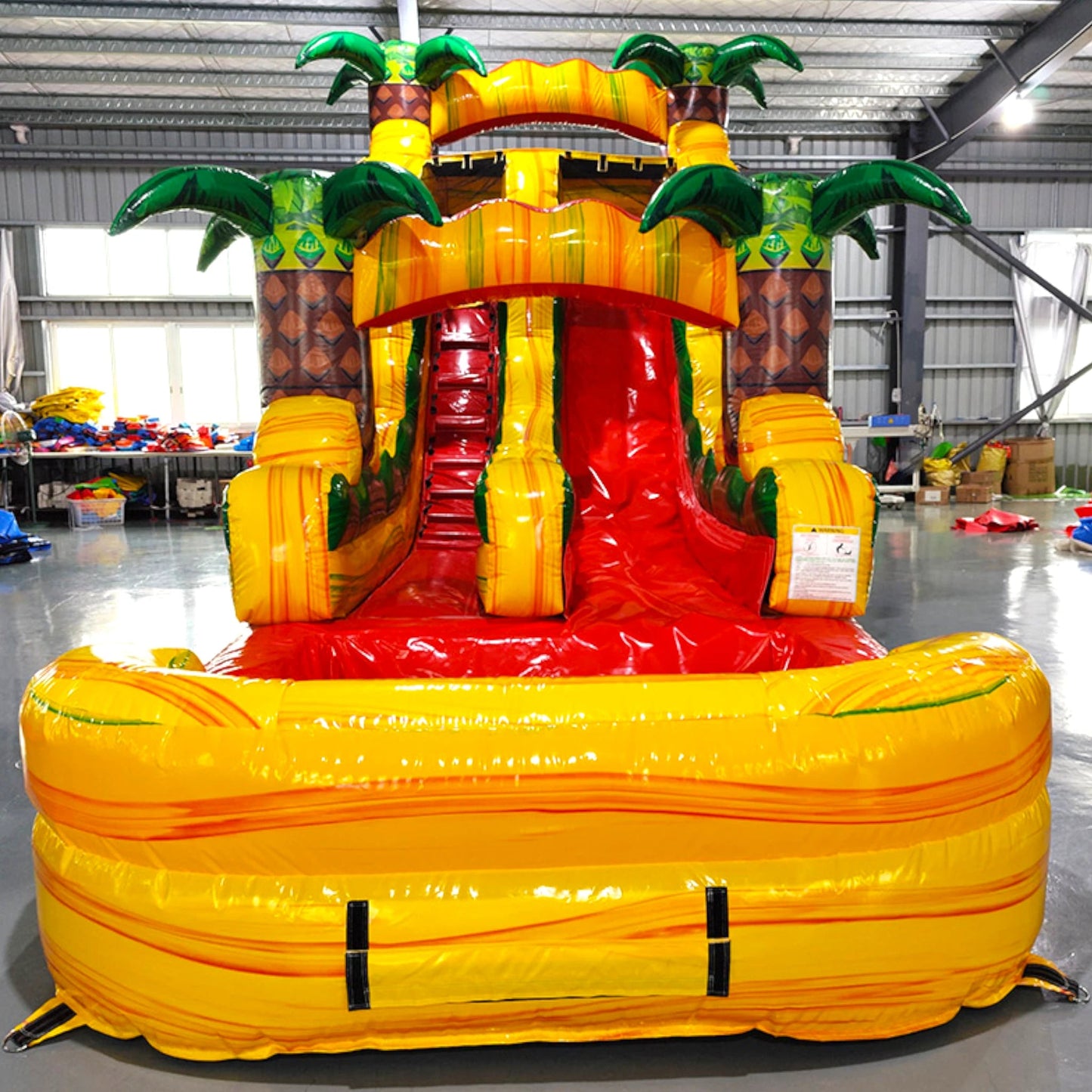 15ft Rasta Splash Commercial Single Lane Inflatable Water Slide front view showcasing yellow structure, red slide, inflatable palm trees, and extended splash pool
