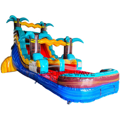 Side view of Tropic Shock single lane water slide showing full length with blue sliding surface, palm tree accents, and large splash area with yellow and blue colors.