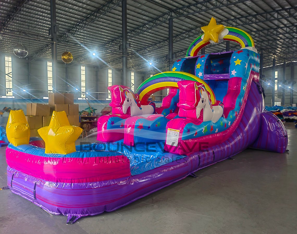 Side view of Unicorn Splash single lane water slide showing full length with blue and pink colors, rainbow arches, unicorn figures, and star-shaped pool floats.