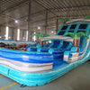 Angled view of 18ft Bahama Blast Center Climb water slide showcasing its full length, three blue sliding lanes, inflatable palm tree decorations, central climbing section, and extended splash pool in an indoor facility.