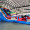 Front view of 18ft Baja Splash Center Climb water slide showing three blue sliding lanes, inflatable palm trees, central climbing area with safety netting, and spacious red and blue splash pool with wave-like patterns.