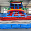 Close-up front view of 18ft Baja Splash Center Climb water slide showcasing the vibrant blue, red, and white color scheme, inflatable palm tree decorations, rainbow arches, and detailed wave patterns on the splash pool.