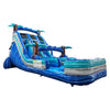 Side view of 18ft Cayman Crush inflatable water slide featuring three blue lanes, tropical palm tree decorations, central climbing structure, and large turquoise splash pool with wave-like patterns against a white background.