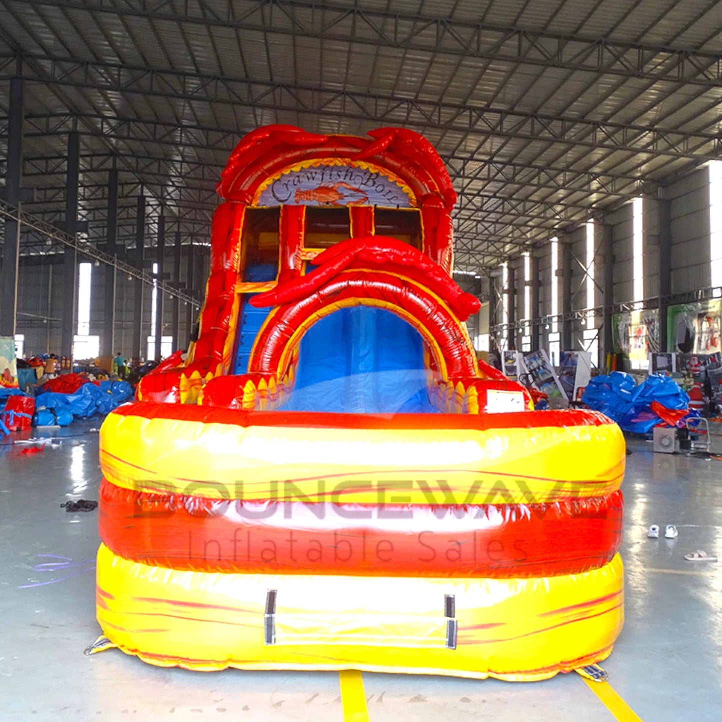 Front view of the 18-foot Crawfish Boil hybrid inflatable water slide in an indoor setting, highlighting its towering red structure, dual lanes, crawfish graphics, and large yellow and orange splash pool, perfect for all-weather use.