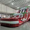 Large inflatable water slide with red base, blue wave patterns, and green palm tree decorations, featuring three sliding lanes and a central climbing structure, set up in an indoor warehouse.