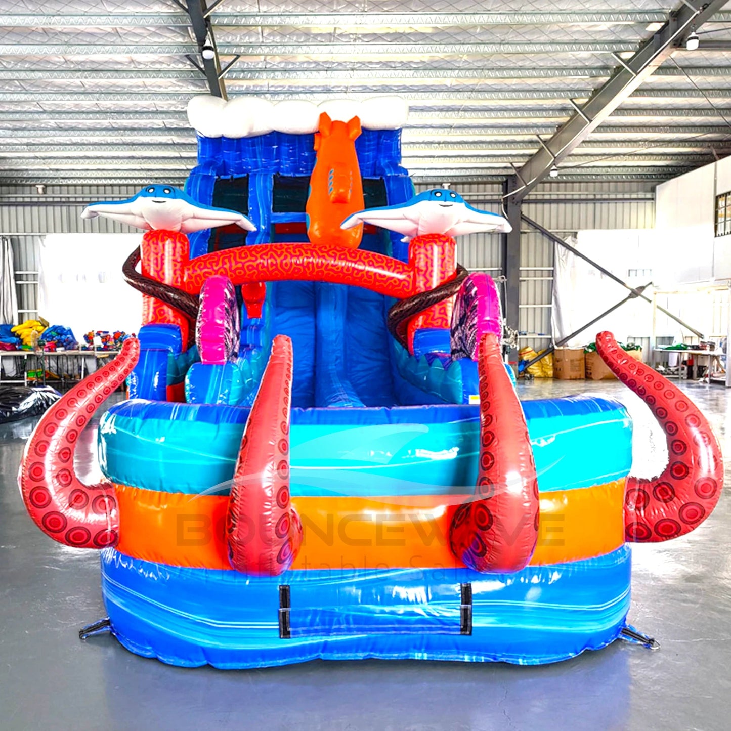 Front view of the 18-foot Deep Sea Dive hybrid inflatable water slide, showcasing its towering height, dual blue sliding lanes, colorful sea life decorations including sharks and octopus tentacles, and a spacious splash area for underwater-themed fun.