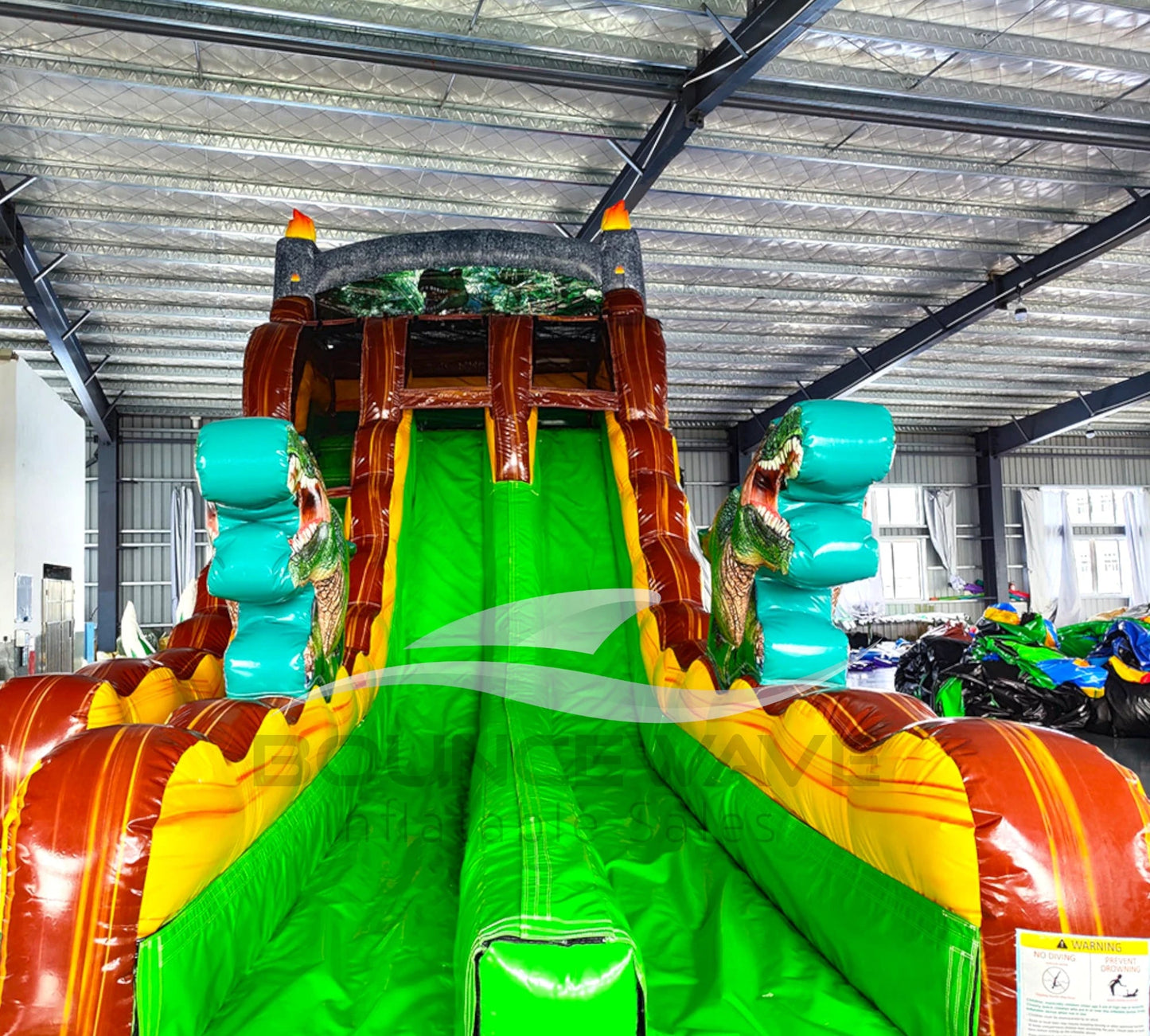 Front view of dinosaur water slide with vibrant colors, dual lanes, and large splash area.