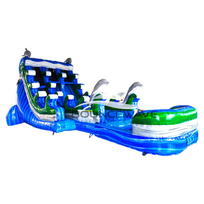 Large inflatable dolphin-themed water slide with dual lanes, blue and green colors, and dolphin decorations.