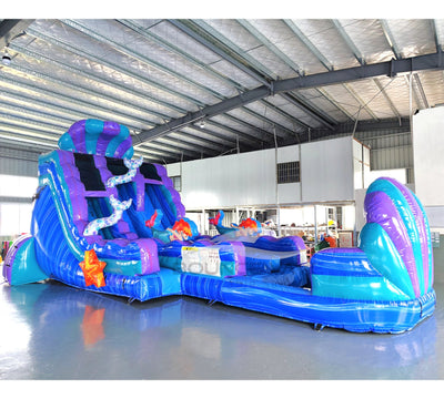 Side view of Mermaid's Cove hybrid water slide showing full length with dual sliding lanes, mermaid decorations, and extended splash pool area.