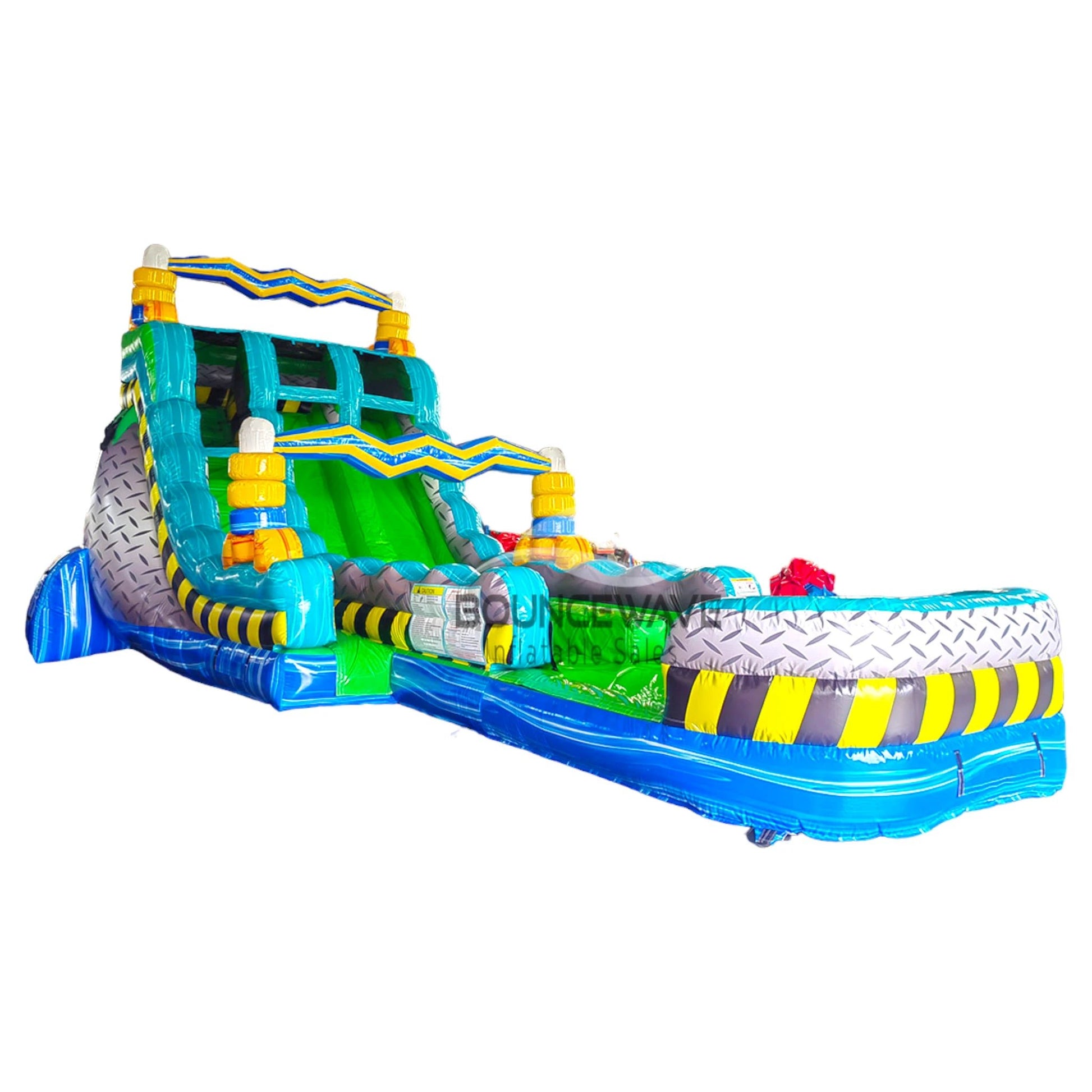 Large industrial-themed inflatable water slide with green and blue colors, featuring dual lanes, caution stripe decorations, and an extended splash pool.