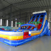 Angled view of 18ft Rip Curl Center Climb water slide featuring blue sliding lanes, inflatable palm trees, central climbing structure, and a spacious splash pool with yellow and white accents, displayed in a large indoor facility.