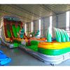 Angled view of 20ft Dino Dive Hybrid DL water slide featuring green color scheme, dinosaur figures, and a large splash pool area. The slide is set up in an indoor warehouse with metal roofing and other equipment visible in the background.