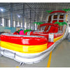 Large inflatable water slide with tropical theme, featuring vibrant red, yellow, and white colors, palm tree decorations, and a spacious splash pool area. The slide combines open and enclosed sections, set up in an indoor warehouse with metal roofing visible.