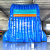 Large inflatable water slide with ocean theme, featuring vibrant blue colors, shark and stingray decorations, and a spacious splash pool area with octopus tentacles. The slide combines open and enclosed sections, set up in an indoor warehouse with metal roofing and other equipment visible in the background.