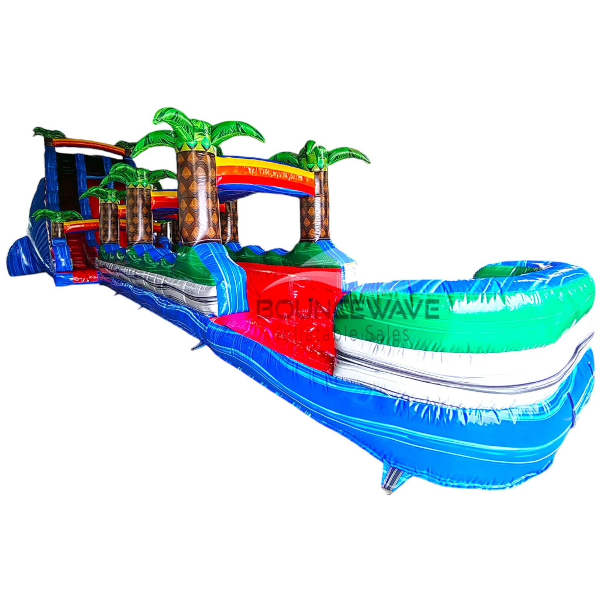 24ft Baja Splash DL 2pc Commercial Water Slide with Inflatable Slip & Slide featuring tropical palm trees, vibrant colors, and curved water slide in warehouse setting
