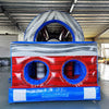 Close-up rear view of 46ft Baja Commercial Hybrid Inflatable Obstacle Course entrance. Features inflatable archway with "START" text, followed by initial obstacles. Red, white, and blue color scheme prominent. Set in a warehouse with metal roofing and concrete floor visible.