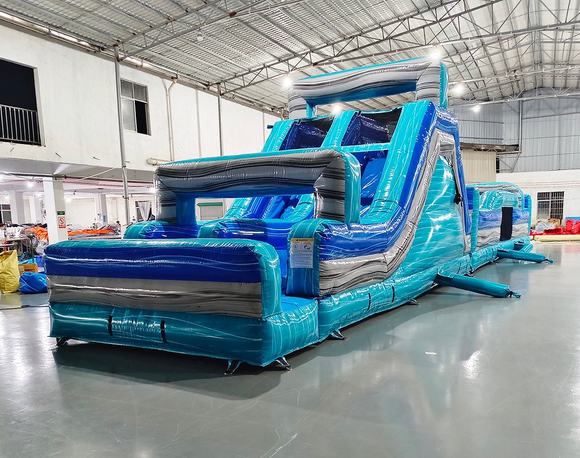 62ft Bahama 2-Piece Wet/Dry Inflatable Obstacle Course side view showcasing blue and turquoise wave-inspired design with multiple obstacles and slides
