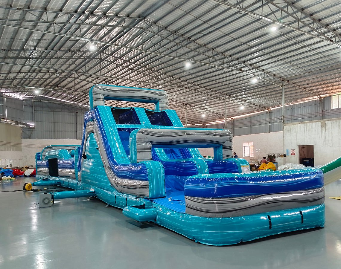 62ft Bahama 2-Piece Wet/Dry Inflatable Obstacle Course angled view highlighting blue and turquoise wave design, obstacle elements, and water slide ending in pool
