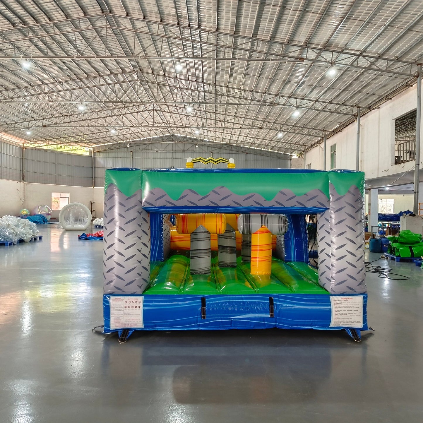 92ft Radioactive Run 3-Piece Wet/Dry Inflatable Obstacle Course front view highlighting yellow hazard-themed structure, inflatable barriers, and blue pool section in warehouse environment
