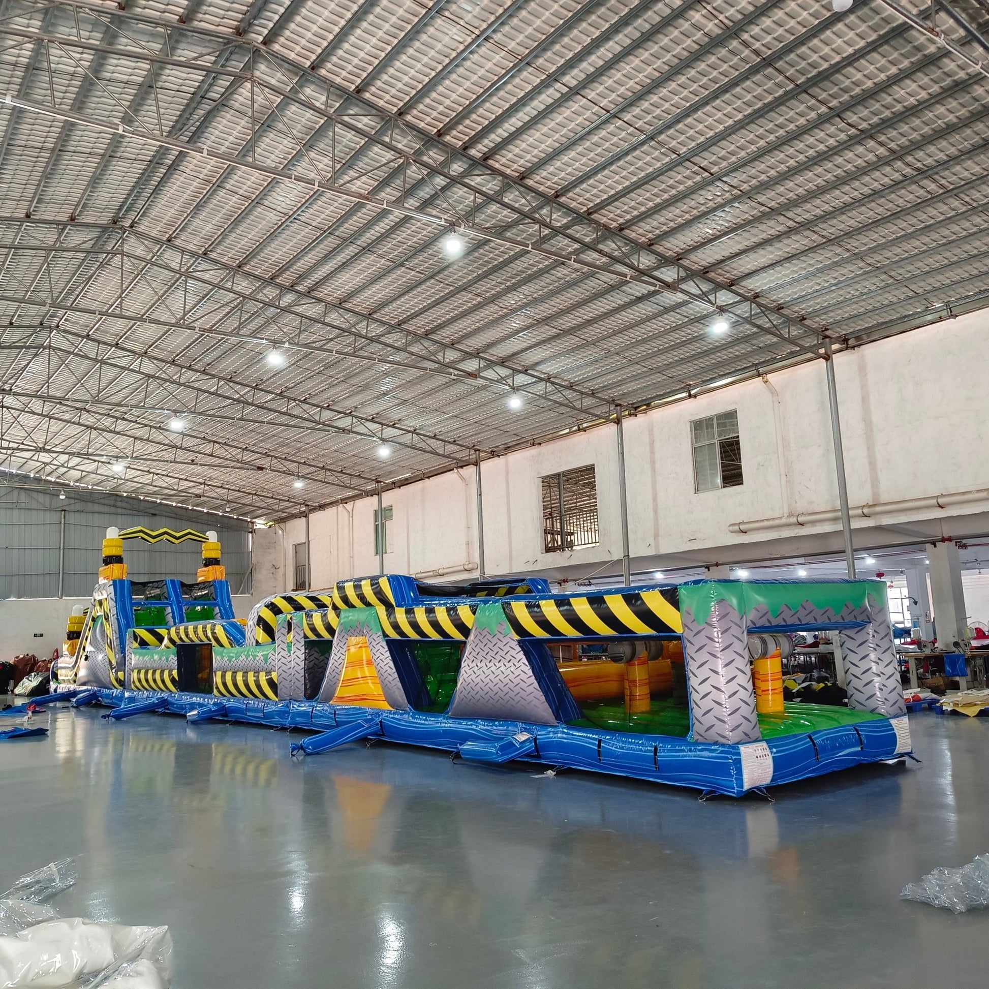 92ft Radioactive Run 3-Piece Wet/Dry Inflatable Obstacle Course side view showcasing long yellow structure with black caution stripes, various challenges, and inflatable pool area
