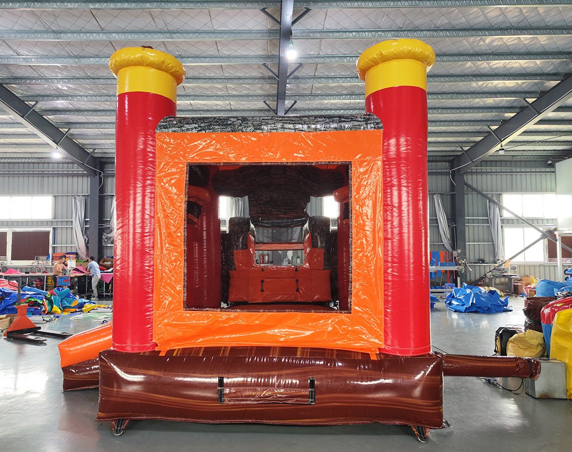 Front view of Buck Shot Econo Combo, showcasing the bounce house entrance with red pillars and yellow tops, orange walls, and a large deer head decoration. Set up in an indoor warehouse with other equipment and inflatables visible in the background.