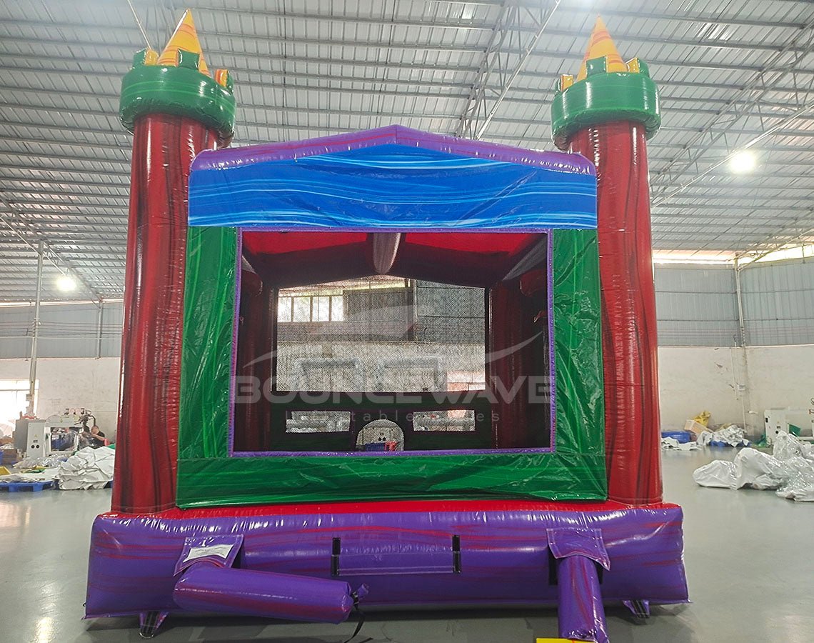 Euro Marble Commercial Grade Bounce House with colorful castle design featuring red towers, green base, and purple entrance in warehouse setting
