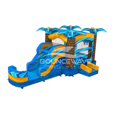 Wide-angle view of Flashpoint Falls Commercial Econo Inflatable Combo featuring a tropical-themed bounce house with palm tree decorations, curved slide, and large splash pool. The inflatable has vibrant blue, yellow, and orange colors and is presented on a clean white background.