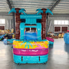 Front view of Island Flow Econo Combo featuring turquoise bounce house with palm trees, colorful slide, and splash pool. Set up in an indoor facility with various other inflatable products and equipment visible in the background.