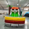 Front view of Lava Raptor Dual Lane Commercial Inflatable Combo featuring a prehistoric theme. The structure has dual slides, one red and one green, emerging from a brown volcano-like base with orange lava patterns. Two large inflatable dinosaurs flank the entrance. Set up in a spacious warehouse with metal roofing and bright lighting visible.