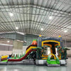 Three-quarter view of Lava Raptor Dual Lane Commercial Inflatable Combo set up in a warehouse. The structure features a brown volcano base with orange lava patterns, dual slides, and large dinosaur figures at the entrance. A colorful splash pool and various inflatable obstacles are visible. The image showcases the combo's size and detailed prehistoric theme in a commercial setting.