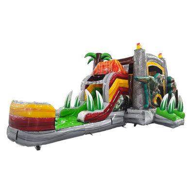 Large inflatable dinosaur-themed combo featuring a volcano-shaped bounce house with lava design, attached slide, and splash pool. The structure has vibrant red, orange, and green colors with realistic dinosaur figures guarding the entrance. Set up against a white background.