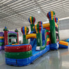 Wide-angle view of Marble Balloon Econo Combo featuring multiple hot air balloon-shaped towers, bounce house, slides, and splash pool area. The inflatable is set up in a spacious indoor warehouse with metal roofing, bright lighting, and other inflatable products visible in the background.