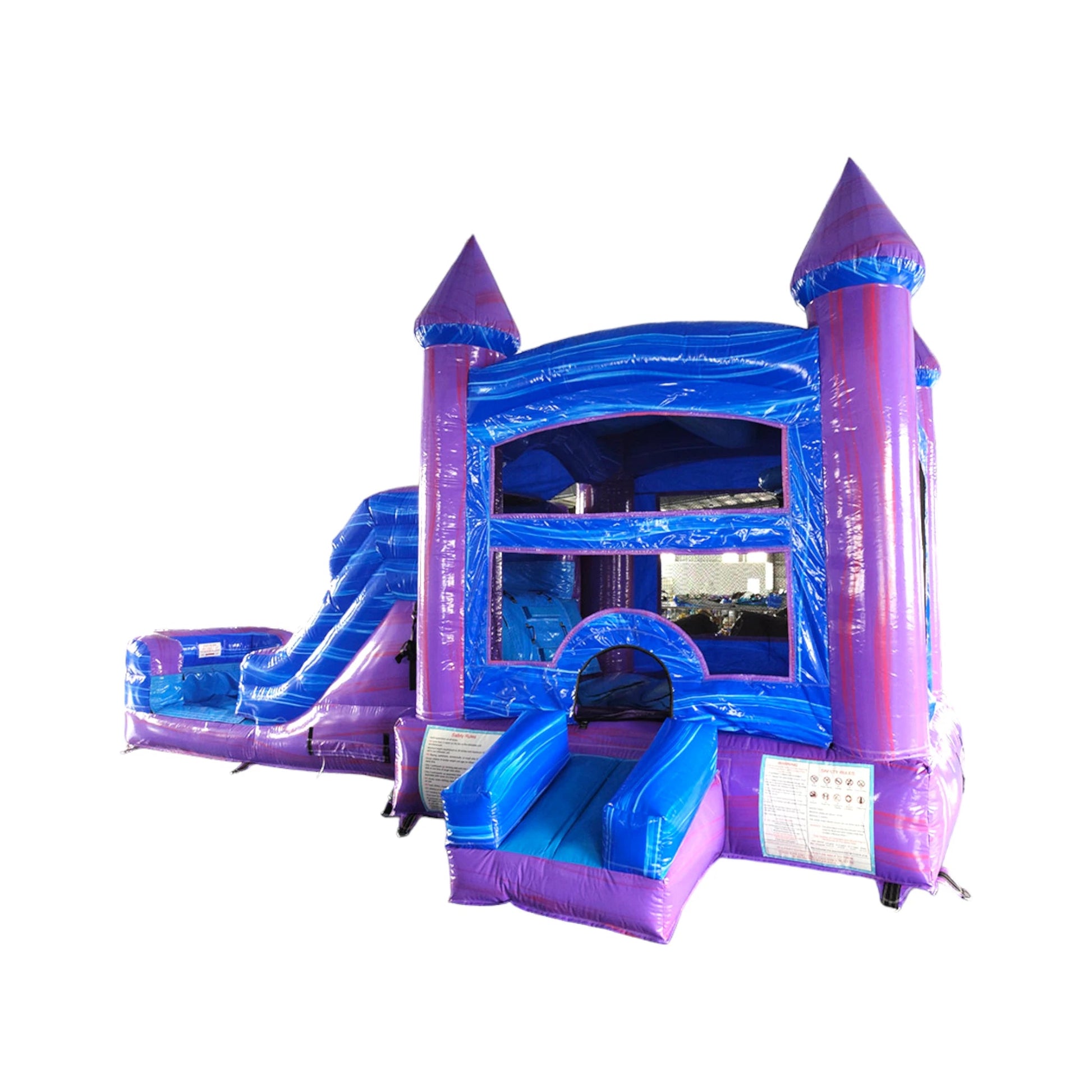 Large inflatable castle-themed combo featuring a bounce house with purple turrets, blue walls, and multicolored accents. Includes a slide, obstacles, and a splash pool area. The structure has vibrant purple, blue, and yellow colors. Isolated on a white background, showcasing its wet/dry functionality.