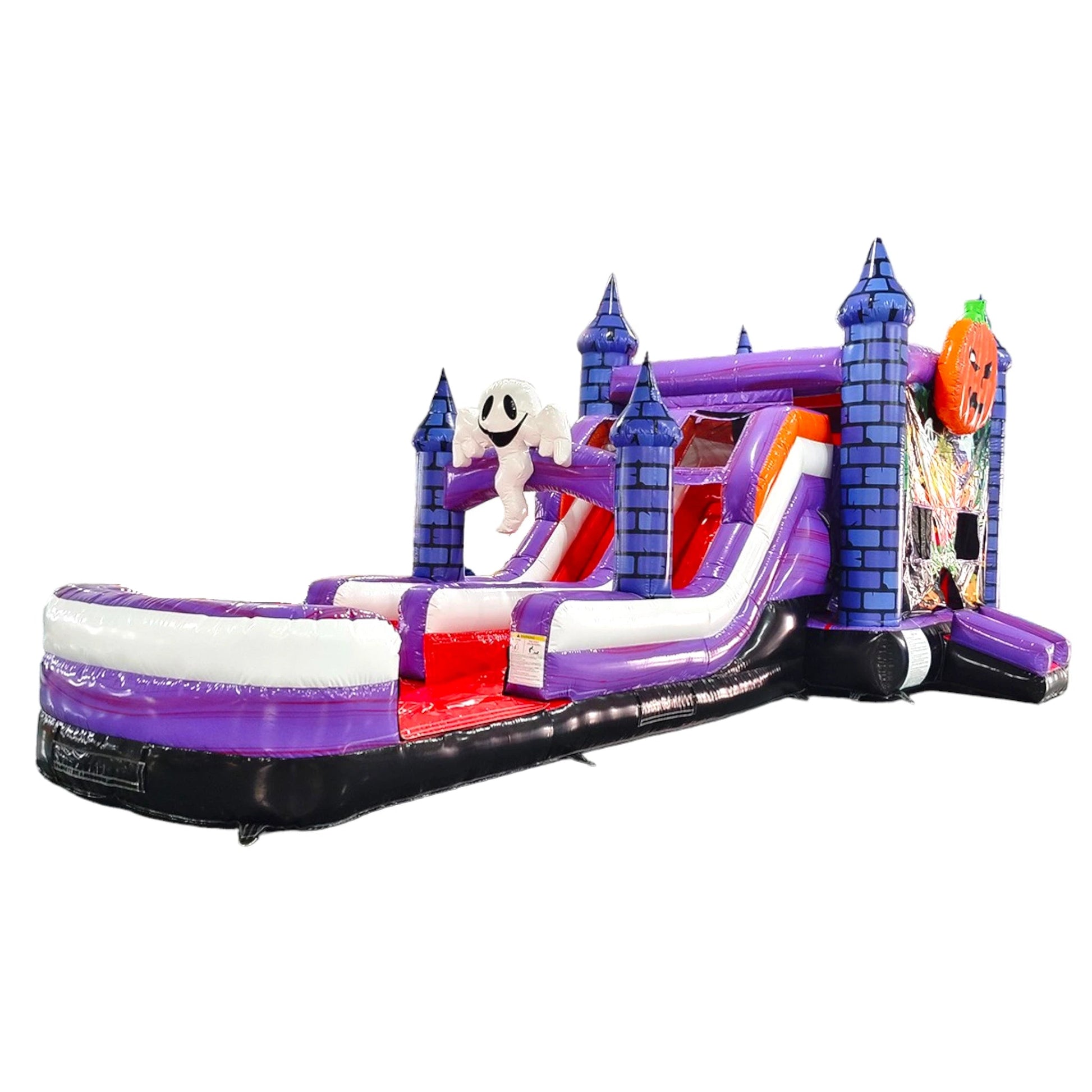 Full view of Spooky Splash Halloween Dual Lane Commercial Inflatable Combo isolated on a white background. The structure showcases blue castle towers, dual slides in red and purple, a large inflatable ghost figure, and an orange jack-o'-lantern on top. A colorful Halloween scene decorates the front panel, and a white and purple splash pool area is visible at the base.