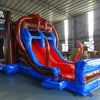 Close-up front view of Tentacle Typhoon Dual Lane Commercial Inflatable Combo (Wet/Dry) showing the entrance area and splash pool. Features a brown ship-like structure with blue trim, large red octopus tentacles wrapping around the sides, and dual slides in red and blue. A blue inflatable splash pool surrounds the base. Black pirate flags with white skull and crossbones are visible on top. Set in a warehouse with concrete flooring and various other inflatable products and equipment in the background.