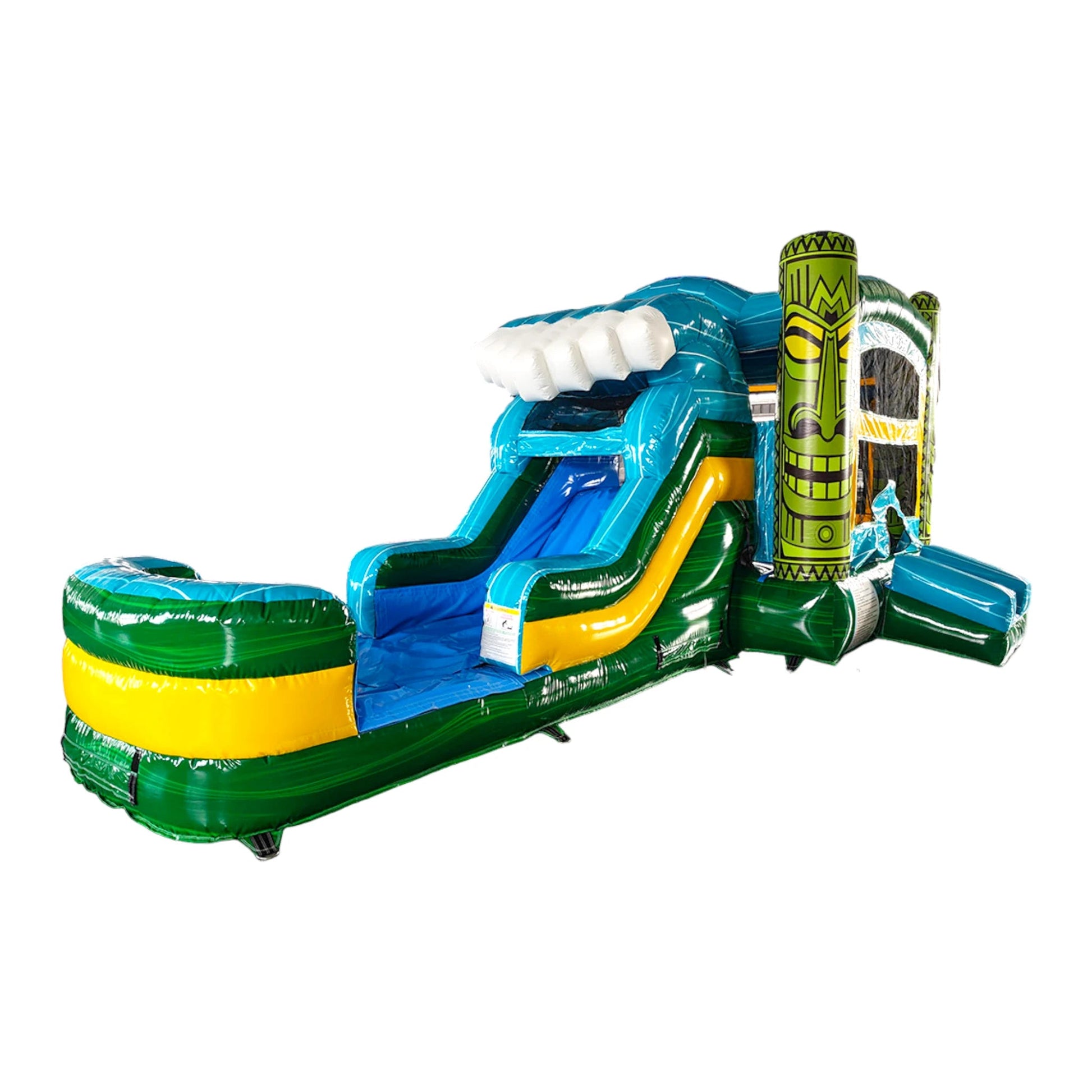 Isolated view of Tiki Wave Commercial Econo Inflatable Combo (Wet/Dry) on a white background. Features a yellow bounce house with green tiki face pillars, blue curved slide with white wave crest, and green base. Inflatable palm trees and mesh windows visible, emphasizing its tropical design and commercial-grade construction.