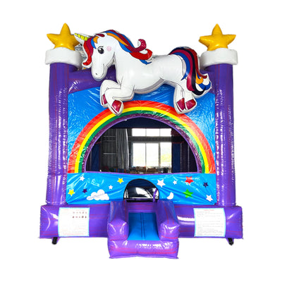 Front view of Unicorn Commercial Grade Bounce House featuring a vibrant purple base with blue sky background. Large white unicorn figure with colorful mane atop a rainbow arch entrance. Yellow stars on purple towers flank the sides. Small blue slide at entrance. Set against a white background, showcasing its whimsical design for commercial use.